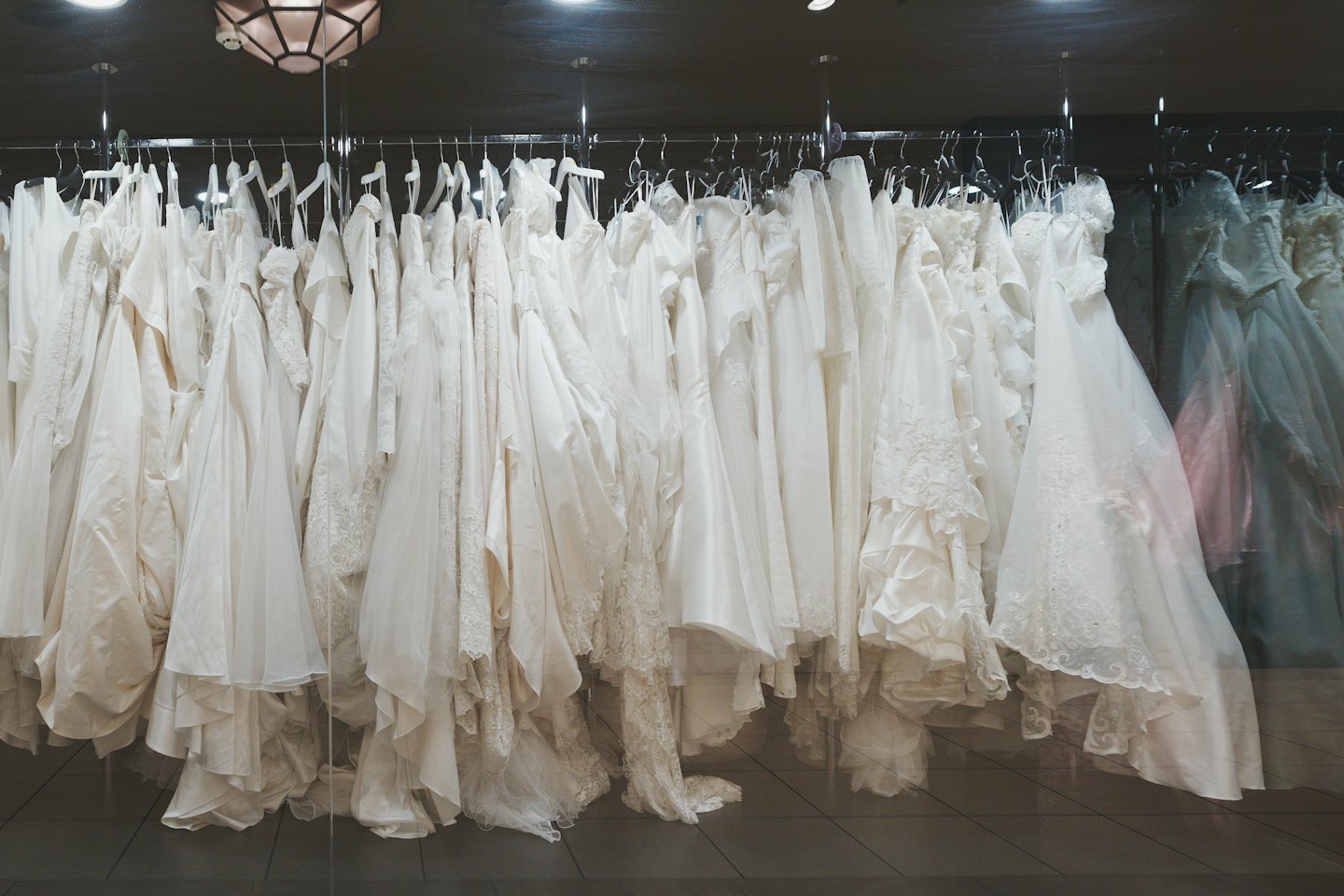 Una rastrelliera di vari abiti da sposa appesi all'interno di una boutique da sposa.