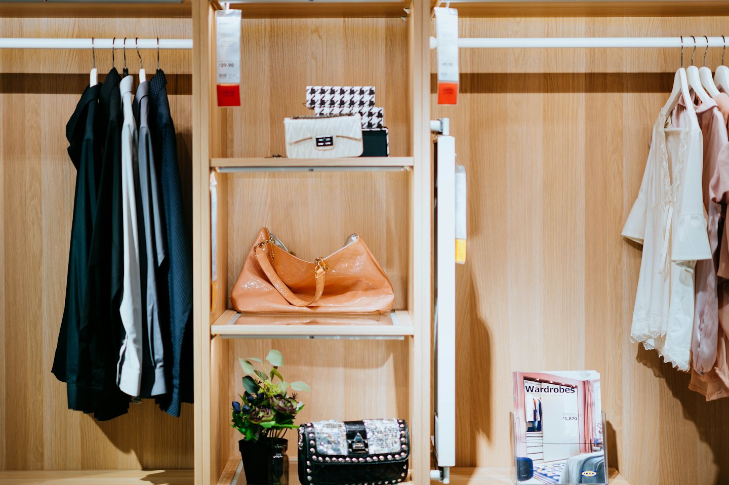 Vestiti e accessori ordinatamente organizzati in un armadio di legno.